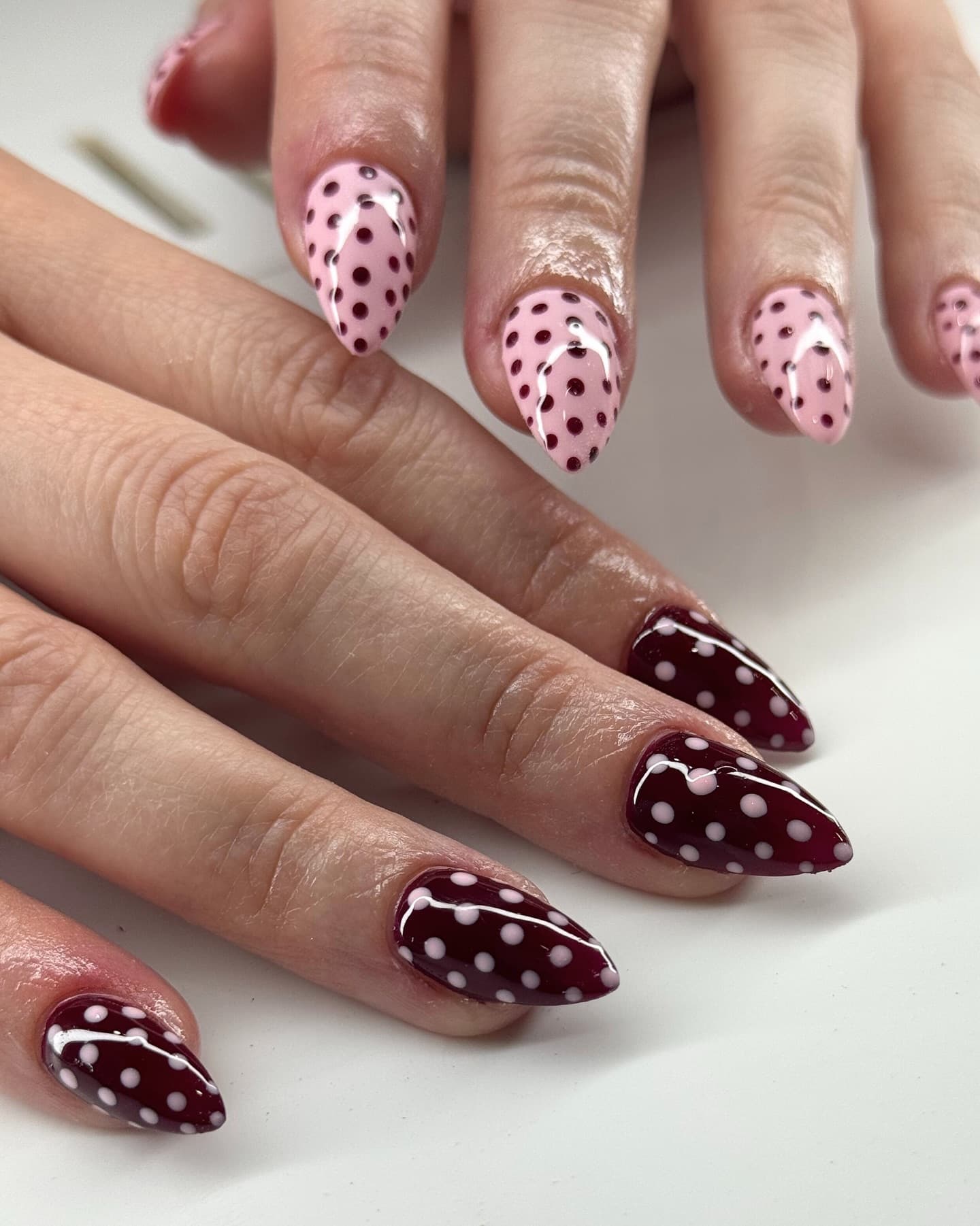 Pink and burgundy stiletto nails with polka-dot nail art