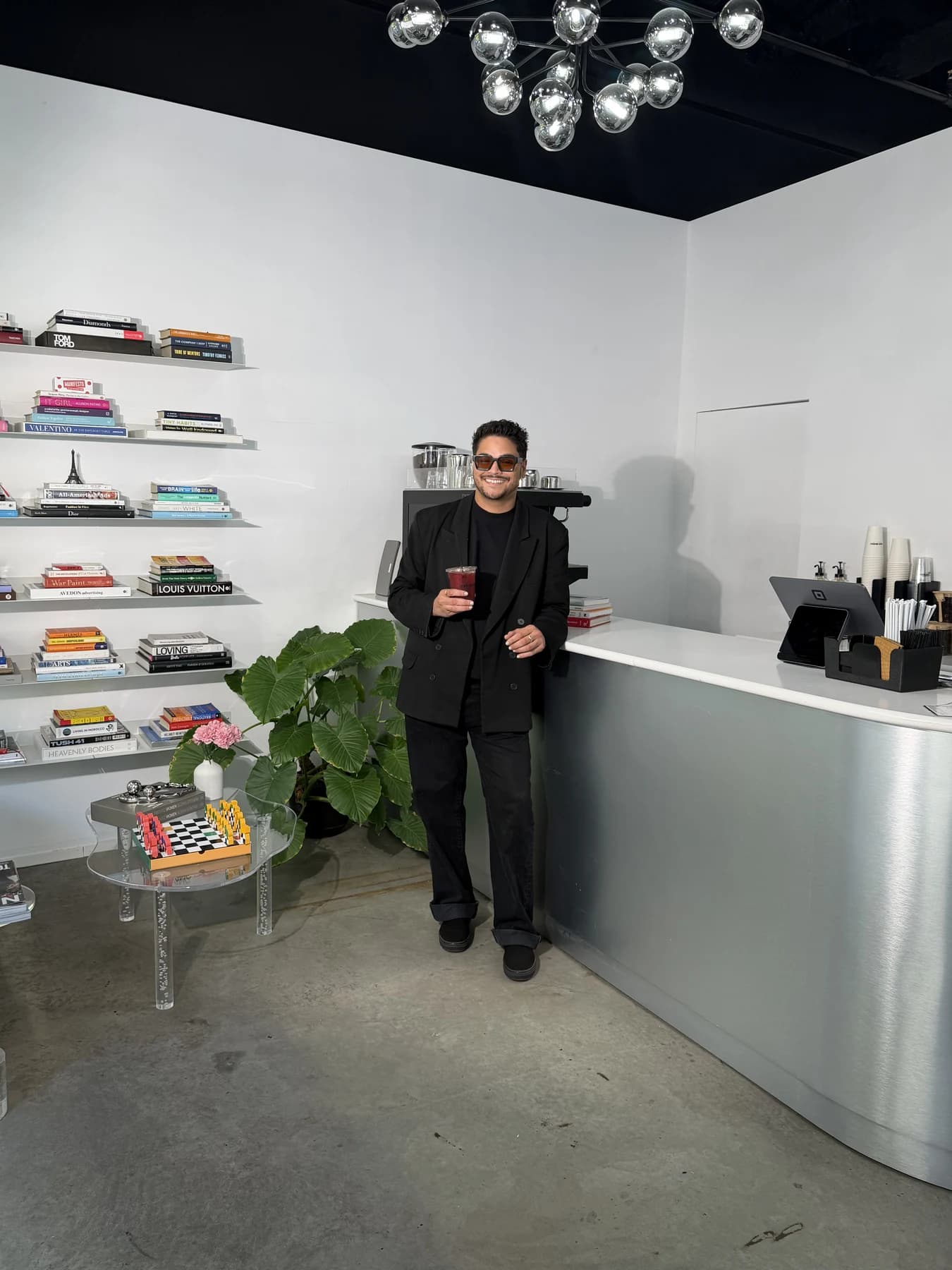 Tomy Rivero standing inside Beauty Cafe beside the bookshelves and cafe counter