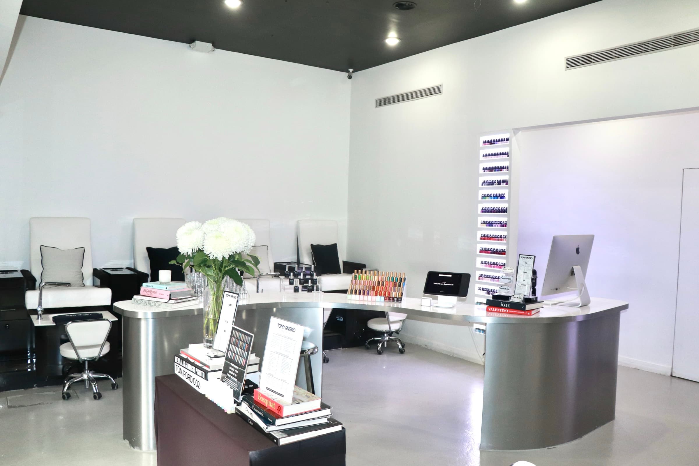 Inside the Tomy Rivero Beauty Lab: reception, pedicure chairs, and the backlit polish wall