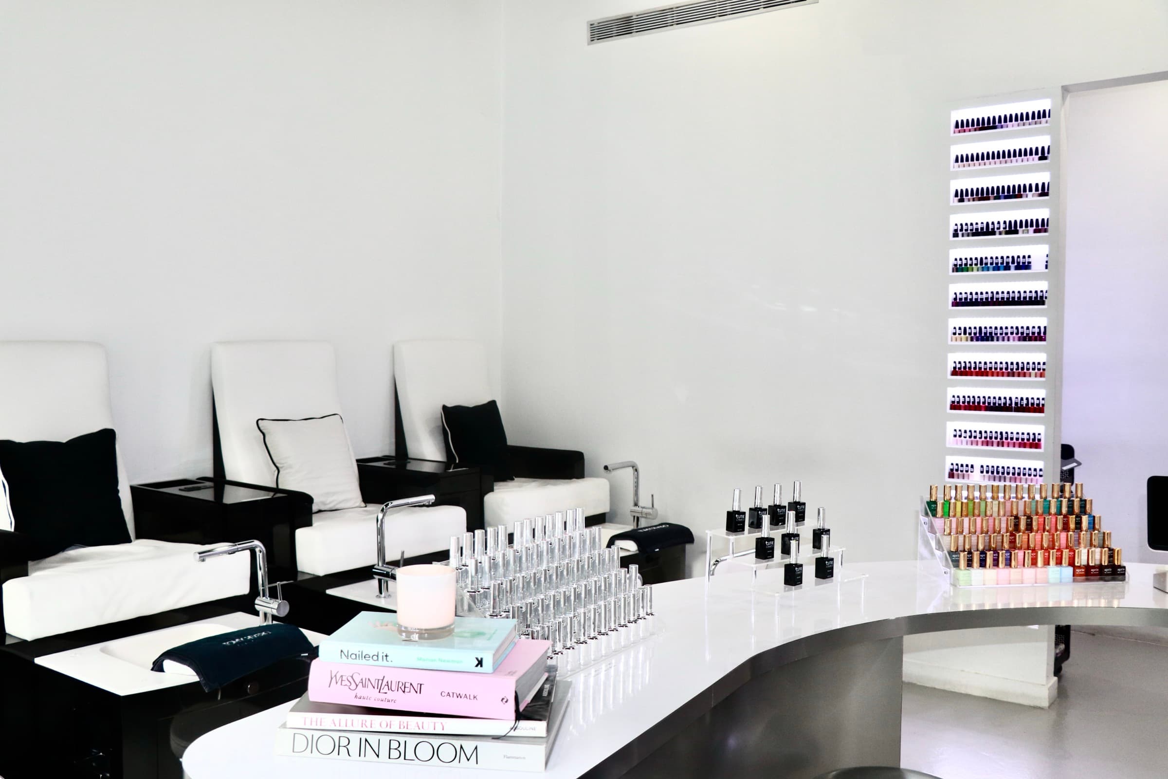 Beauty Lab nail polish wall display next to styled fashion books